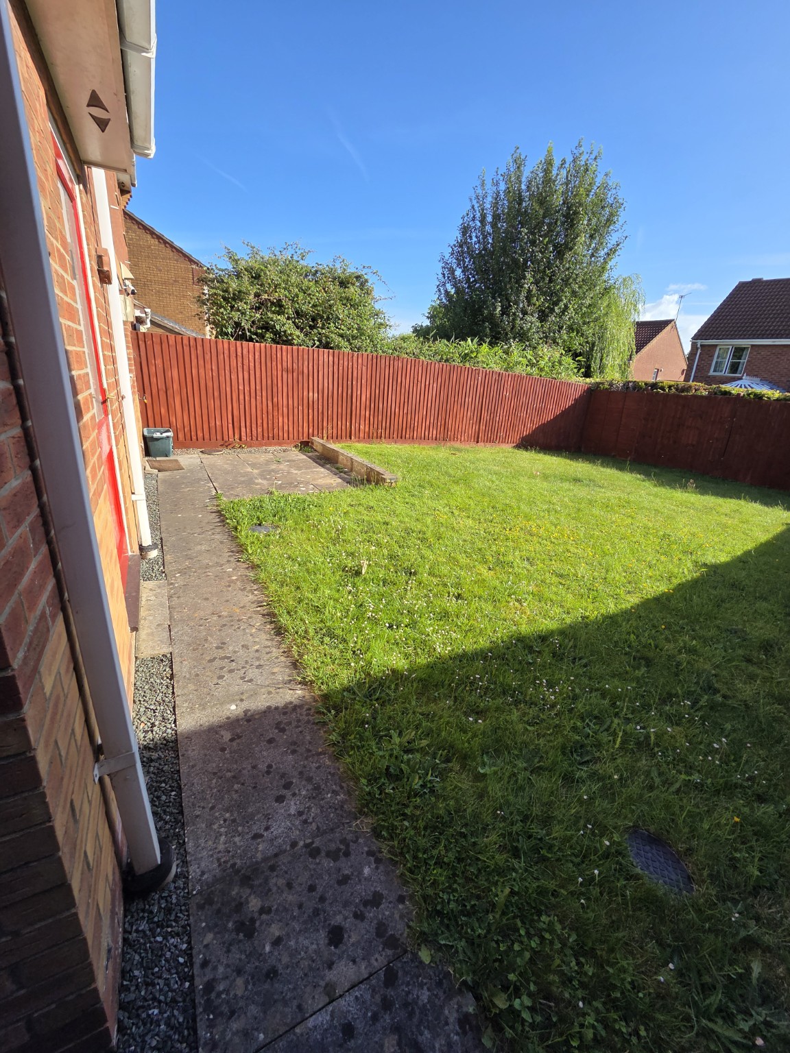 Original lawn and narrow concrete path beside the house in Bristol