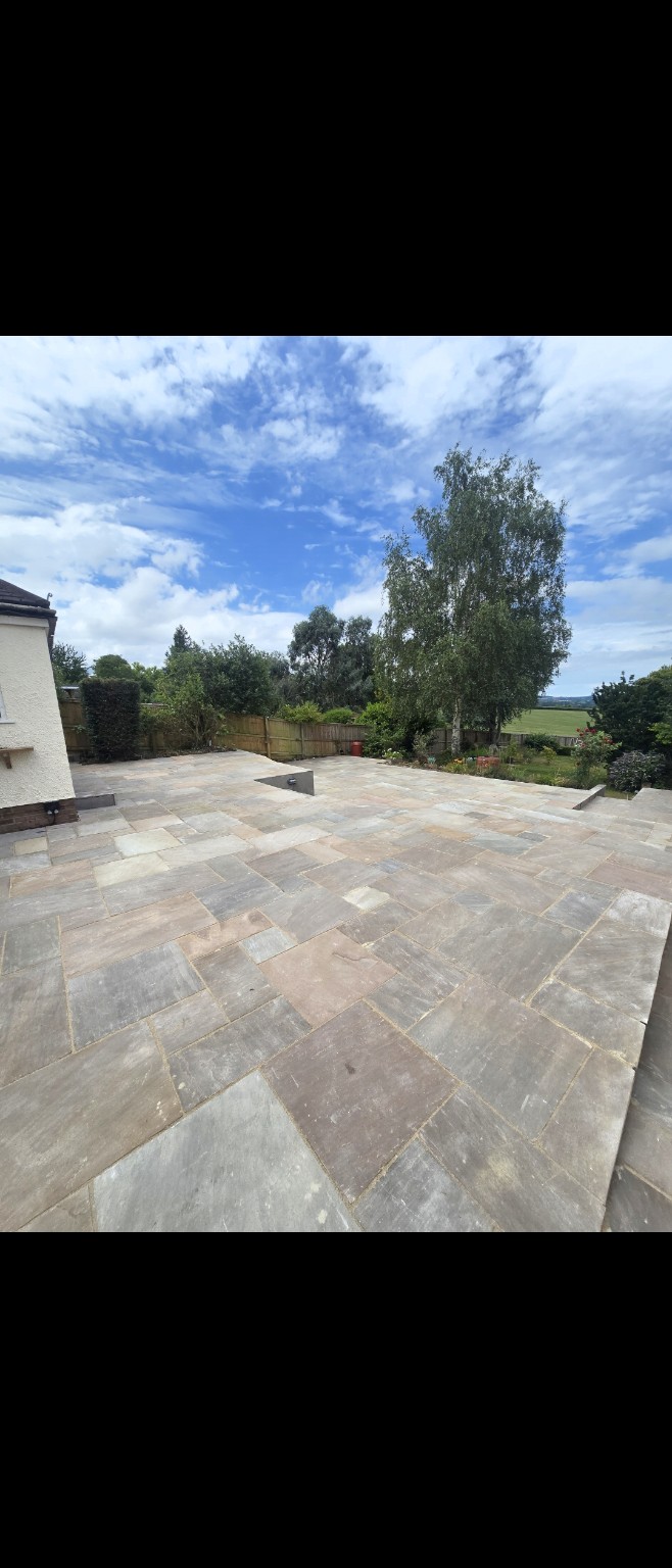 Large Indian sandstone patio extending towards the garden at Mr Hayman’s Taunton property