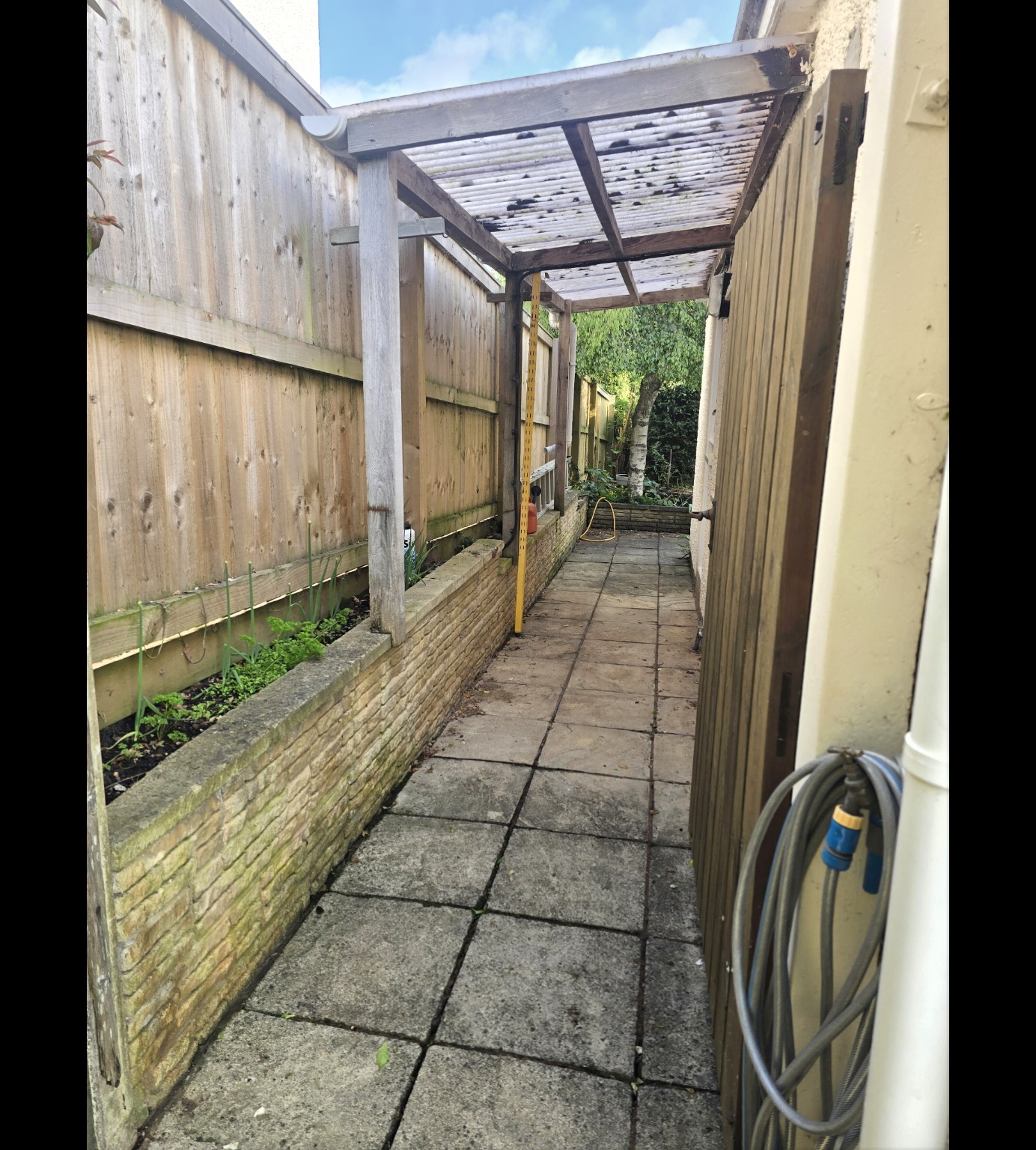 Old square paving beneath a timber canopy beside Mr Hayman’s house in Taunton