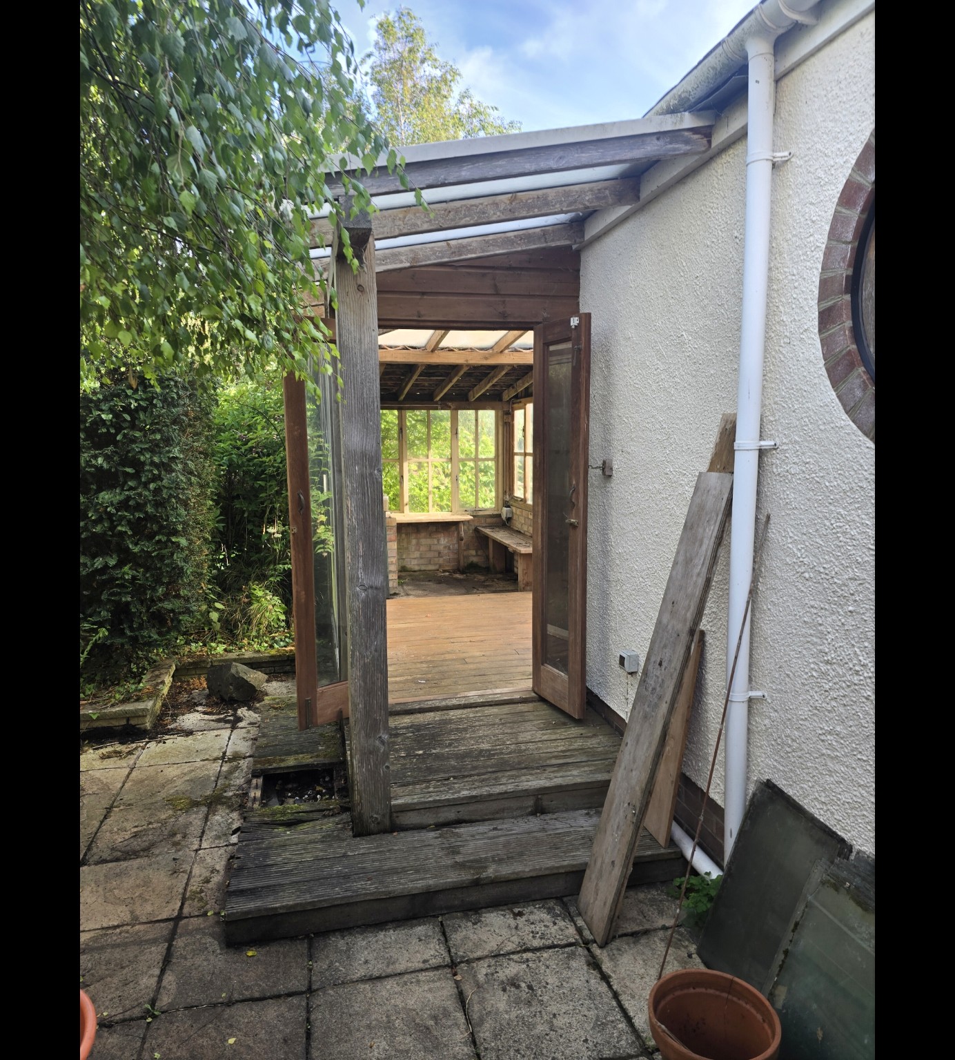 Timber framework and old paving beside the house before the Taunton project