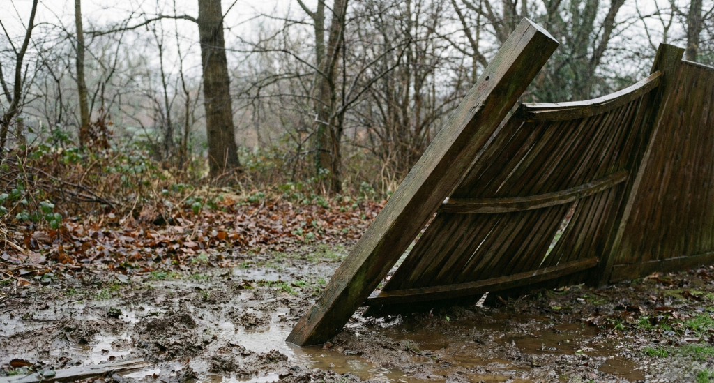 Loose fence posts and saturated ground are early warning signs that storm damage is likely without reinforcement.
