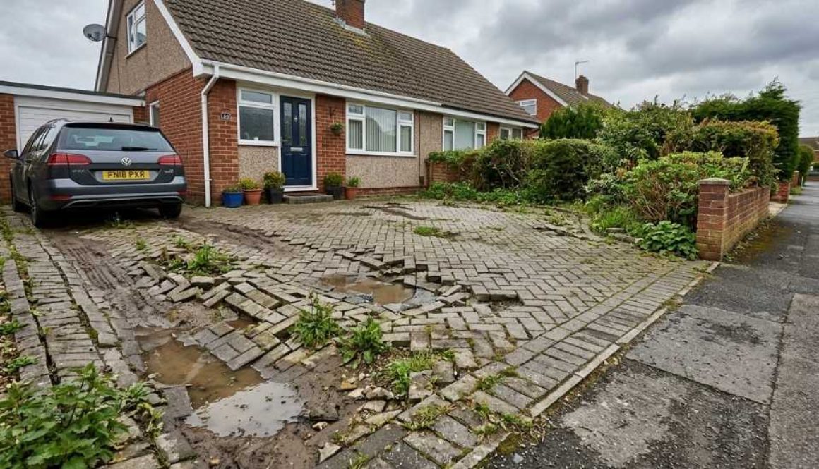 Failed driveway with visible sinking and uneven paving