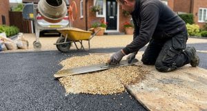 Installer trowelling resin bound aggregate onto a prepared base during a Taunton driveway installation